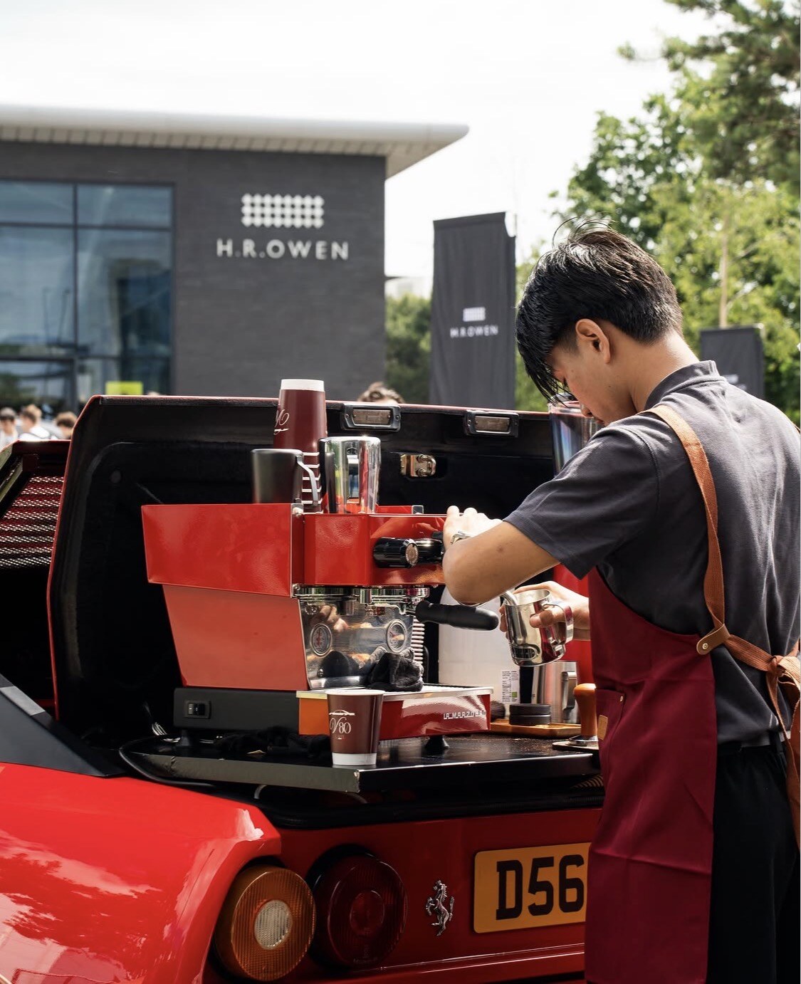 Barista serving coffee from the Ferrari at H.R. Owen